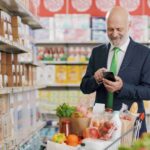 businessman-using-smartphone-supermarket_11zon