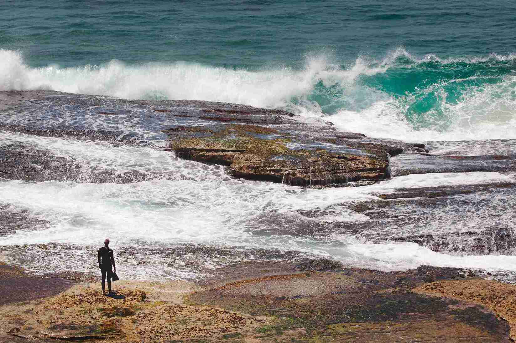 beautiful-shot-person-s-silhouette-standing-rock-near-beach-looking-waves_11zon
